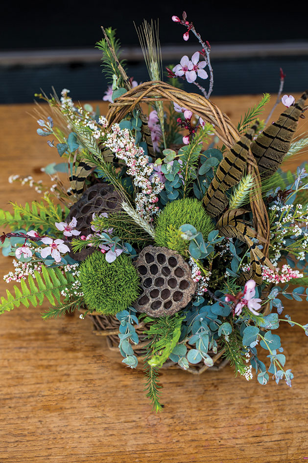 May basket with flowers and feathers