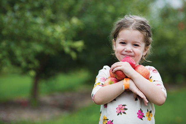A girl holds apples at Apple Jack Orchards
