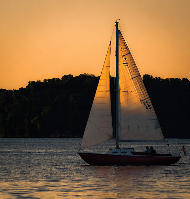 A sailboat sails at sunset on Lake Minnetonka.