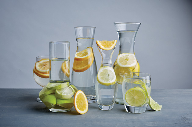 A collection of picthers containing fruit water.