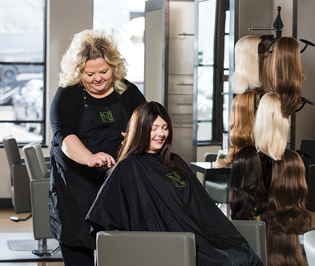 A stylist at Nedia Hair Loss Salon & Spa works on a patient's hair.