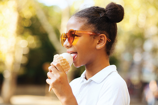 A girl eats an ice cream cone. 