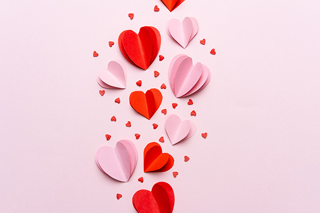 Paper hearts on a pink background.