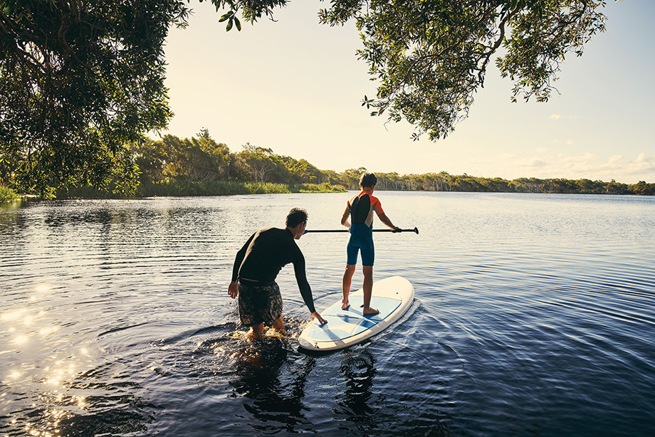 Shot of a father and son enjoying a day outdoors on a paddle board.