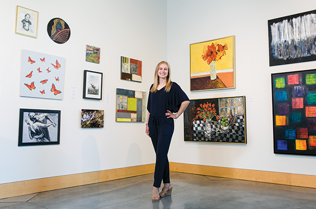 Anna Wander, member of the 2019 Senior Spotlight, stands in front of a wall of art.