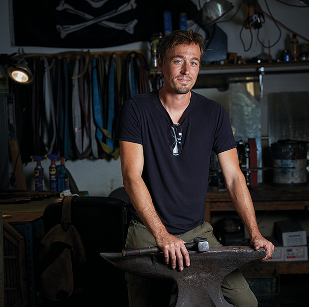 Jason Kraus, owner of Northstar Forge knife-making business, stands with his forging equipment