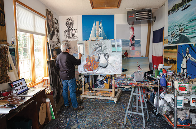 Local artist Richard Merchan paints in his studio in Greenwod