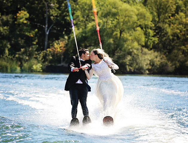 A Minnetonka couple water skis in their wedding attire for their unique save-the-date photo.