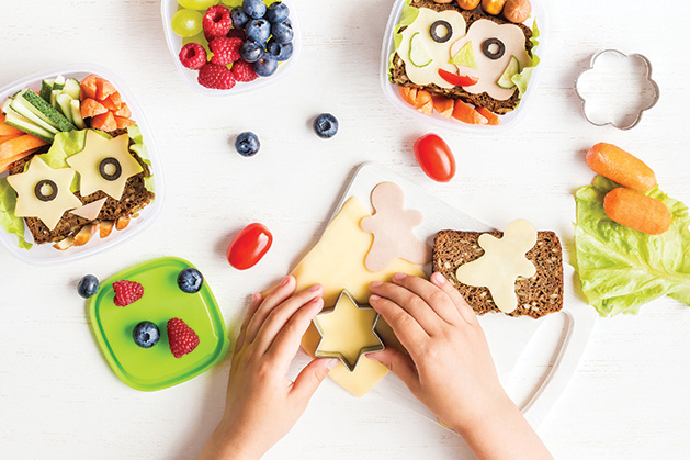 A child uses a cookie cutter to make fun sandwiches.