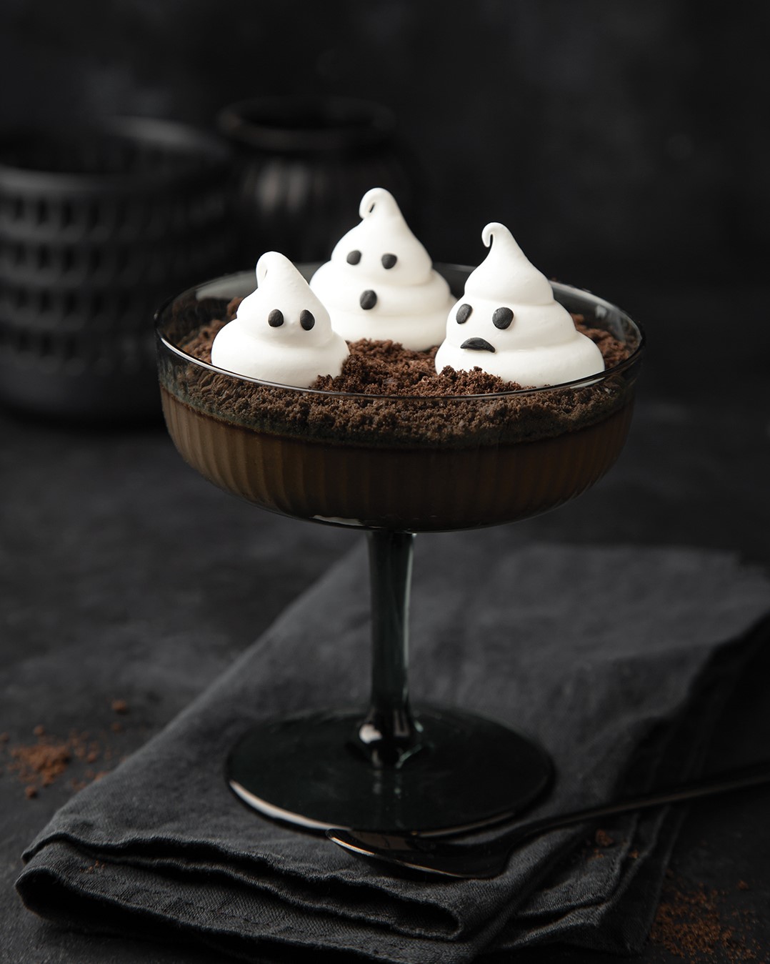 Halloween dessert idea - Cocolate Panna Cotta with chocolate cookie crumbes and meringue ghosts, black background