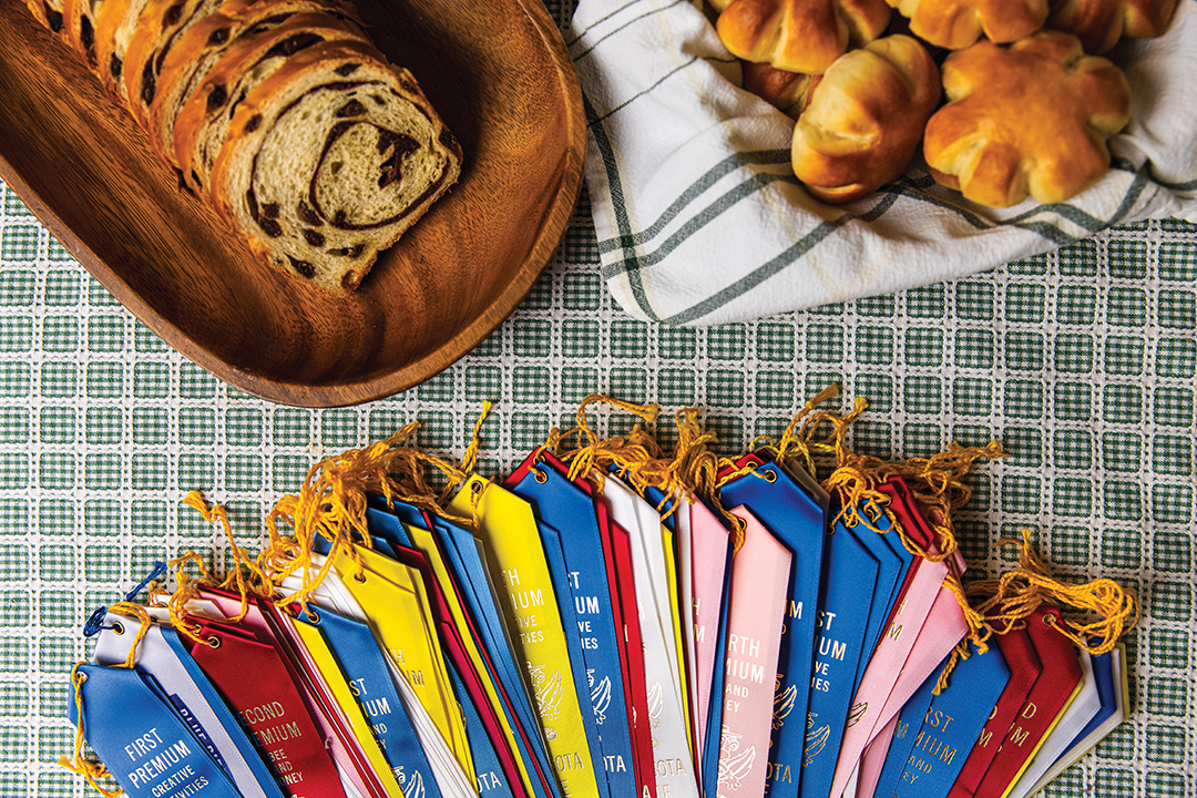 Jim Lind has an large display of award ribbons alongside his blue ribbon-winning Cinnamon-Raisin Bread and Posies Dinner Rolls.