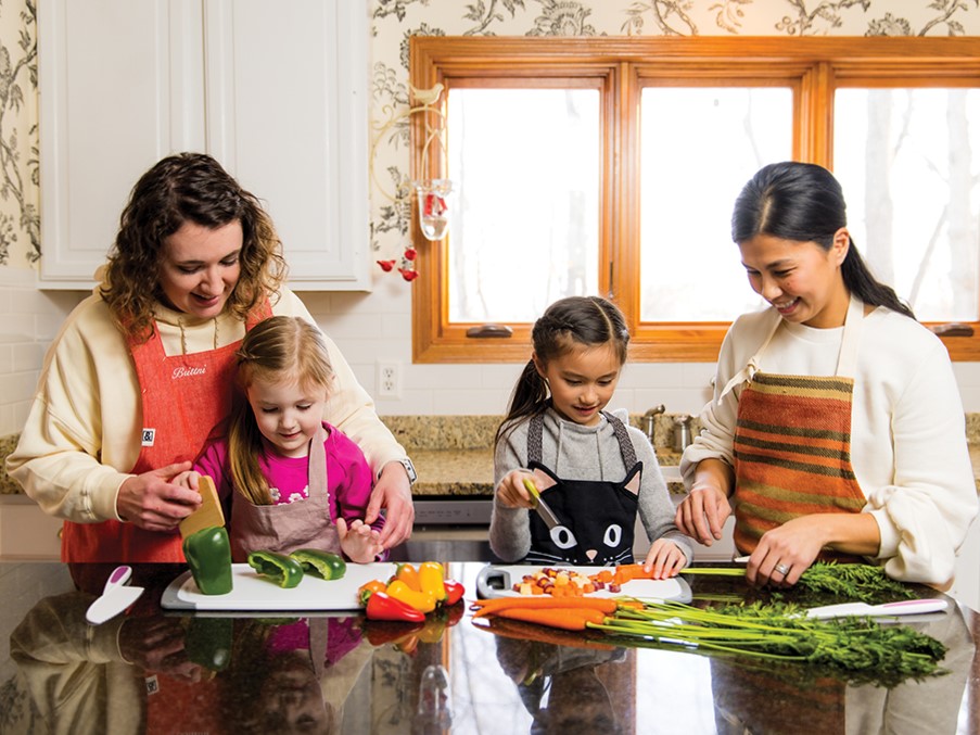Taking a cue from the MCE cooking class, Brittni Dye and her daughter, Ellie, 3, and Mimi Coz and her daughter, Olivia, 7, practice making empanadas.