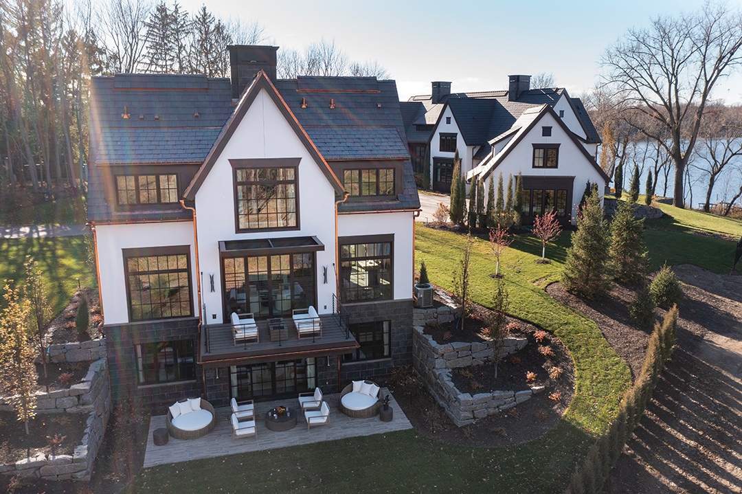 In a pleasing echo of the main house, the guest house boasts a lower level that walks out to a wide patio, offering views of Lake Minnetonka and a shady, secluded spot for drinks or solo pursuits, reading, daydreaming or come what may. “The furnishings we used on the patio were selected based on linear silhouettes and the clean geometry of midcentury modernism,” Aniuska Payares says. “We selected neutral colors and materials, with wood tones and the use of stone for the coffee table, side table and fireplaces, adding different textures to the whole composition.” An upper-level deck has plenty of seating, too, and a clever awning that shades the space from the sometimes-harsh summer sun.