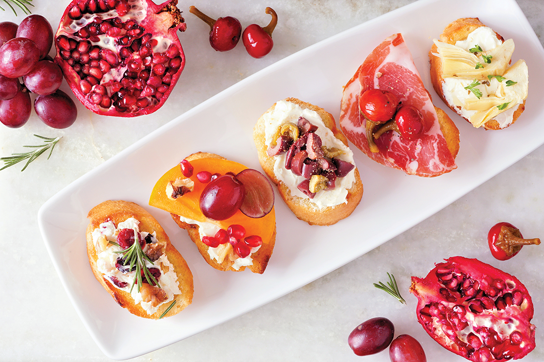 Assortment of crostini appetizers with a variety of toppings. Above view table scene on a bright background. Party food concept.