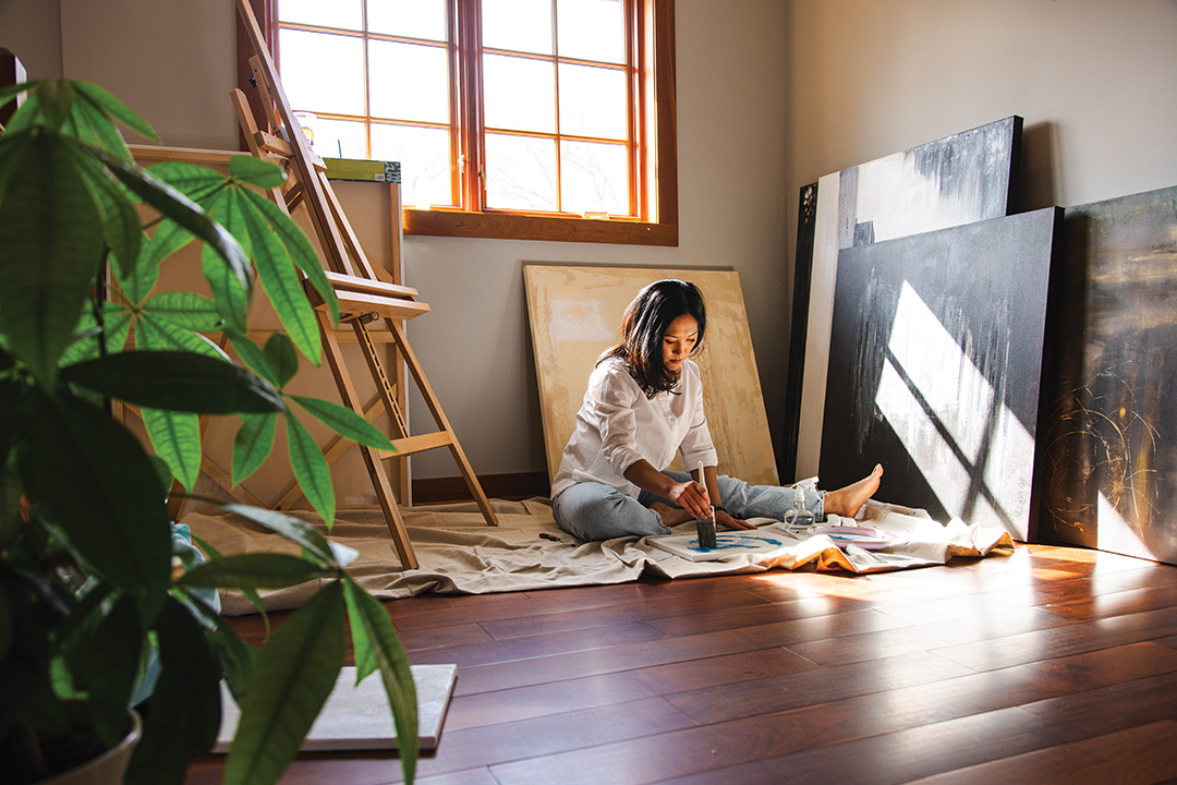 Lost in creative thought in her home studio, AJ Lindstrom-Oye spends several hours each week painting; her goal is to finish one piece each month.