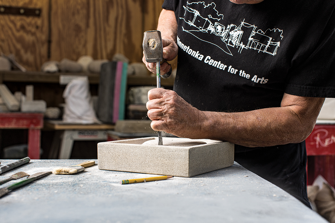 Frank Picos carving stone at Minnetonka Center for the Arts