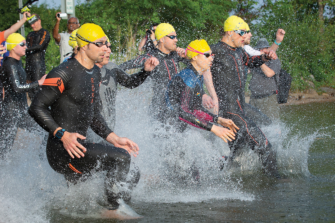 Triathletes charge into Lake Minnetonka for another leg of their race, which returns June 21 in Excelsior.