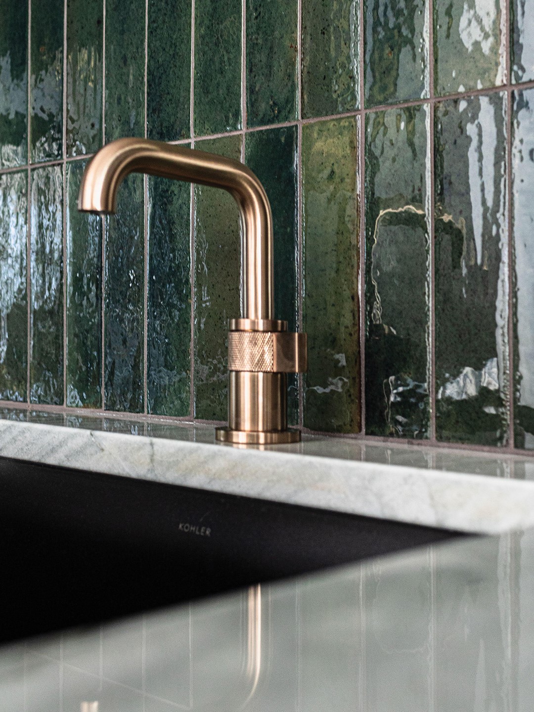 Orono home bar with brass sink hardware and green tile backsplash.