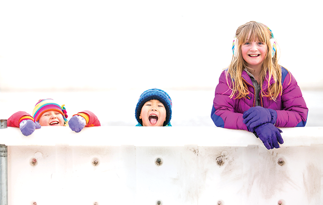 Three kids at an ice rink