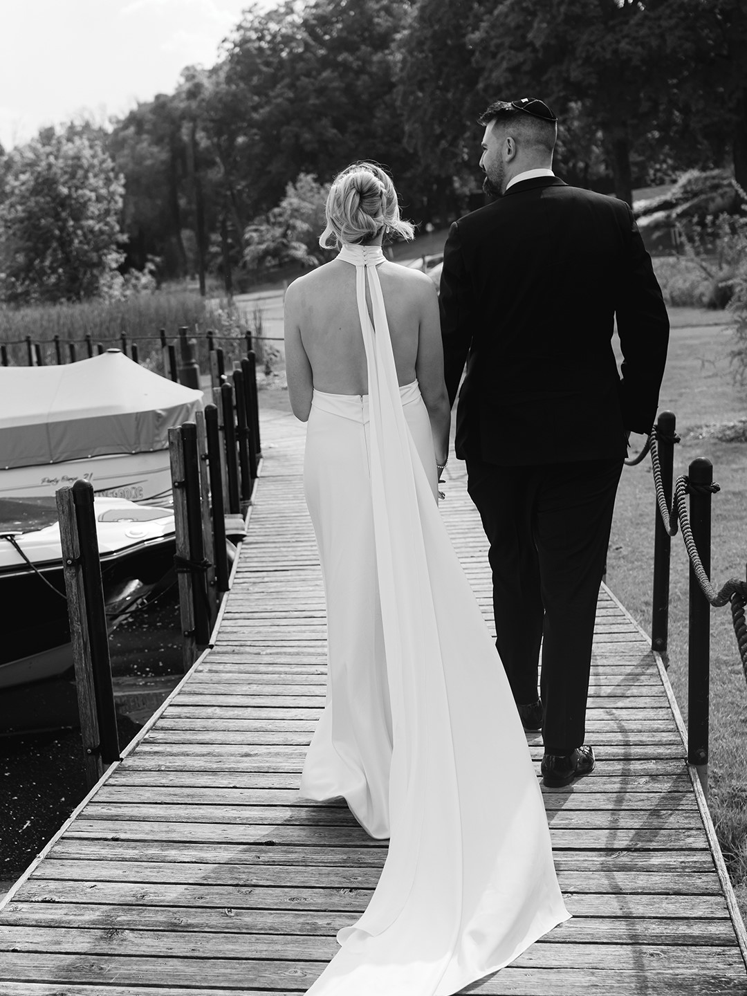 Purchased in WONA NYC the bride wore a sheath wedding dress, designed by Eva Lendel, crafted from glossy satin fabric with a deep V and halter-style neckline with a backless design. The pièce de résistance might be the decorative train, which flowed from the neckline to the floor. 