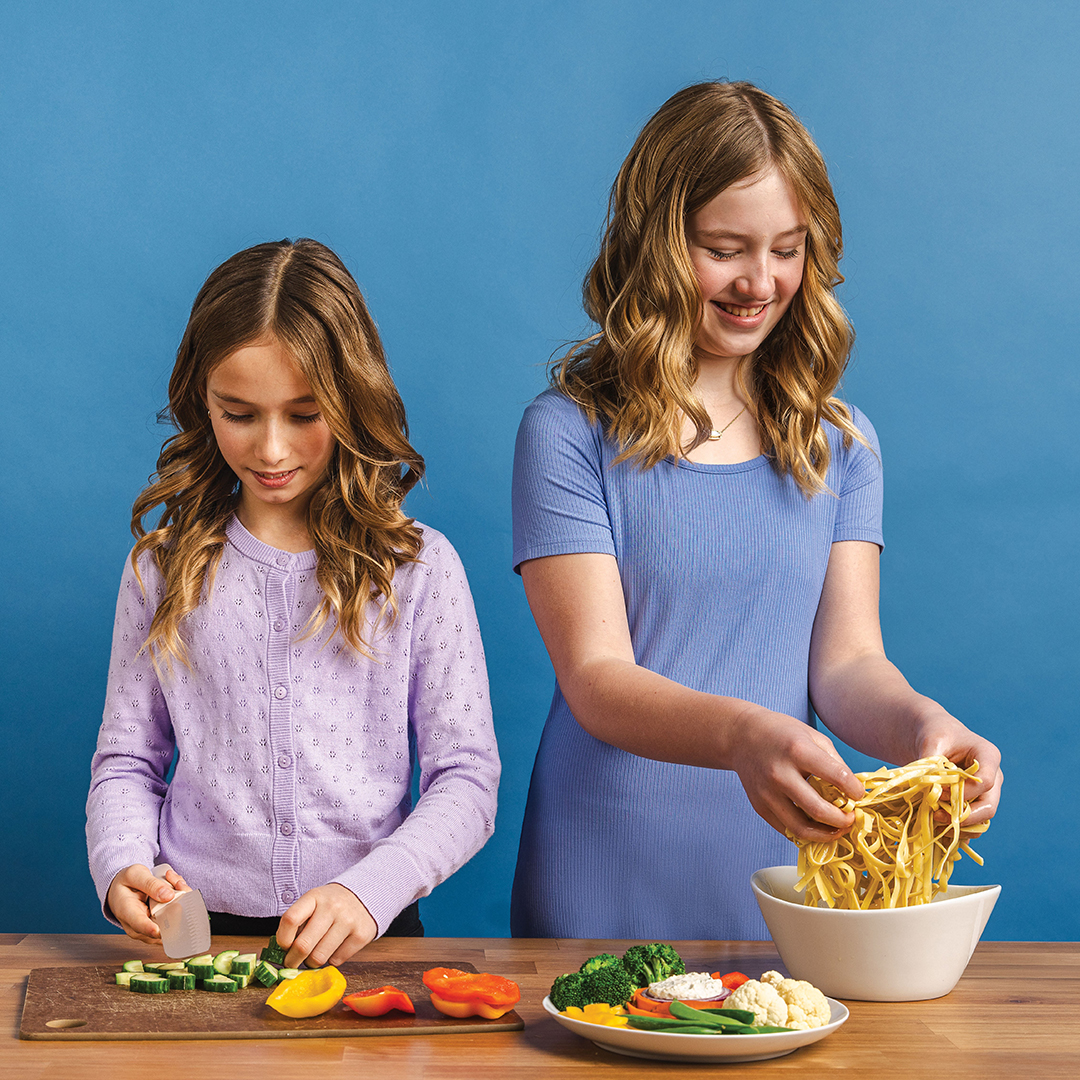 Joor Erin’s daughters Lauren, 9, and Bauer, 11, chop vegetables and prepare handmade pasta noodles, learning their way around the kitchen as Erin did as a child with her parents. 