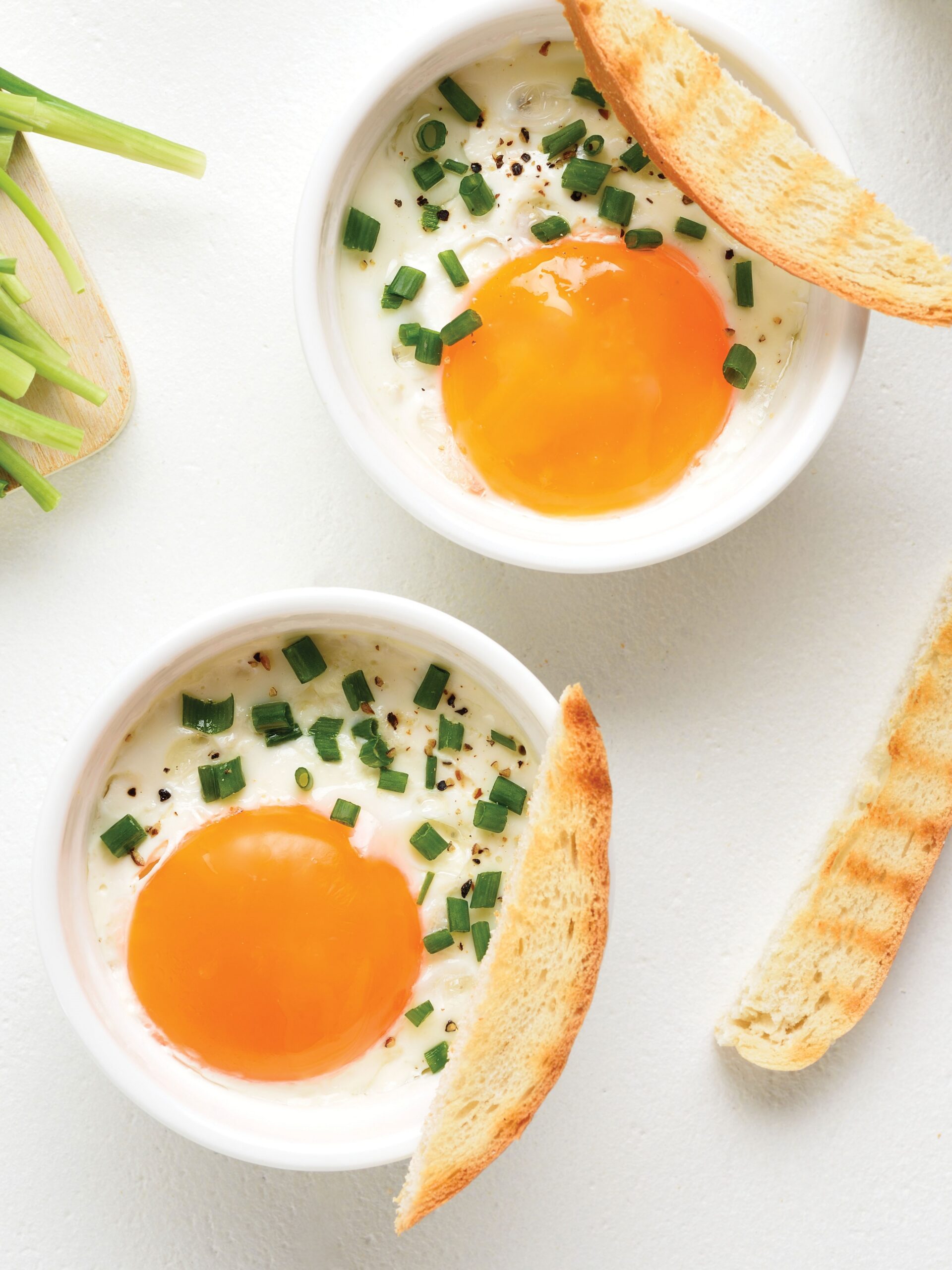 Baked eggs with chives and baguettes