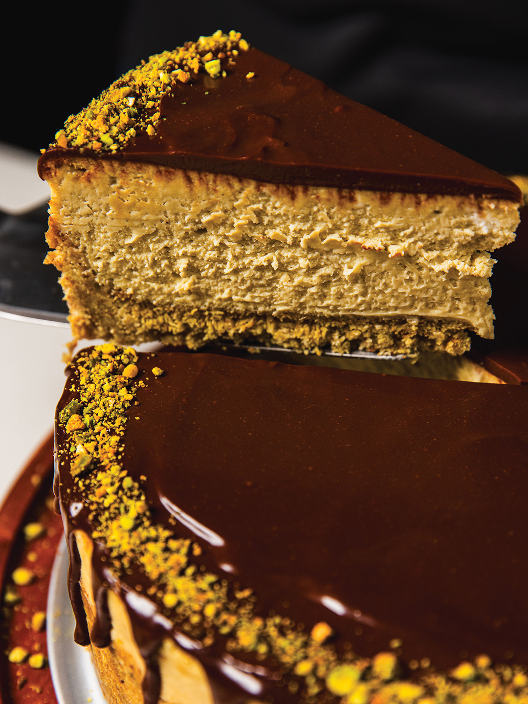 Slice being lifted out of Dubai Chocolate Cheesecake