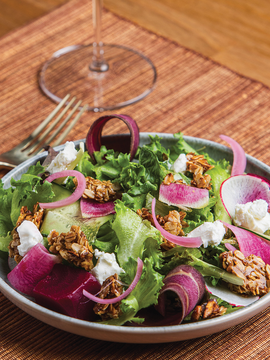 This salad features cucumber, goat cheese, granola, purple carrot and watermelon radish.