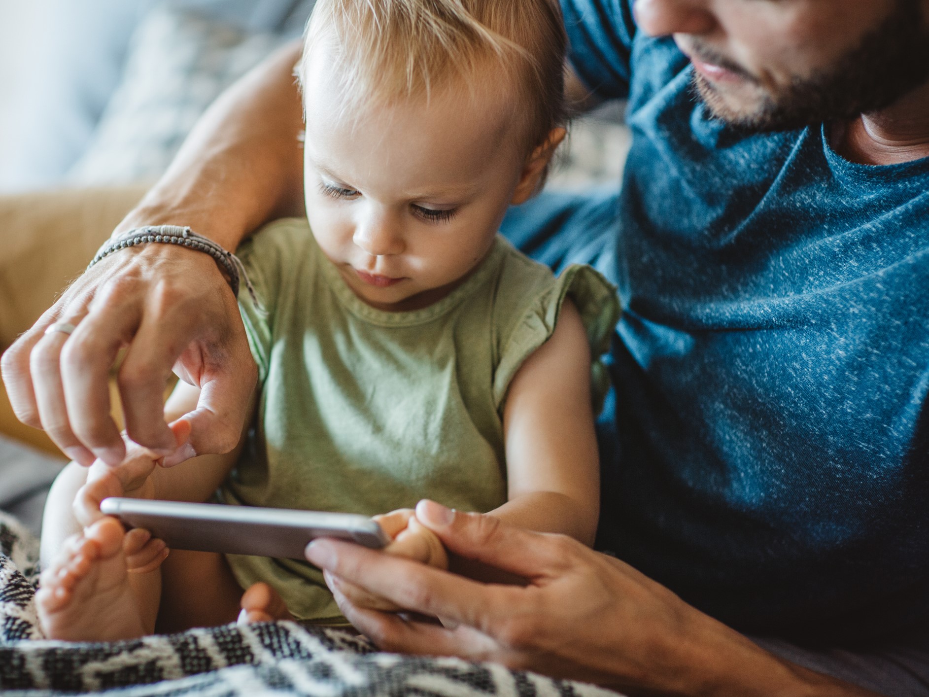 Father and son listening to a story on a phone
