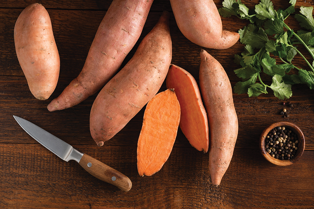 Sweet potatoes, batatas on wooden and linen background, ready for cooking. Healthy organic vegetables